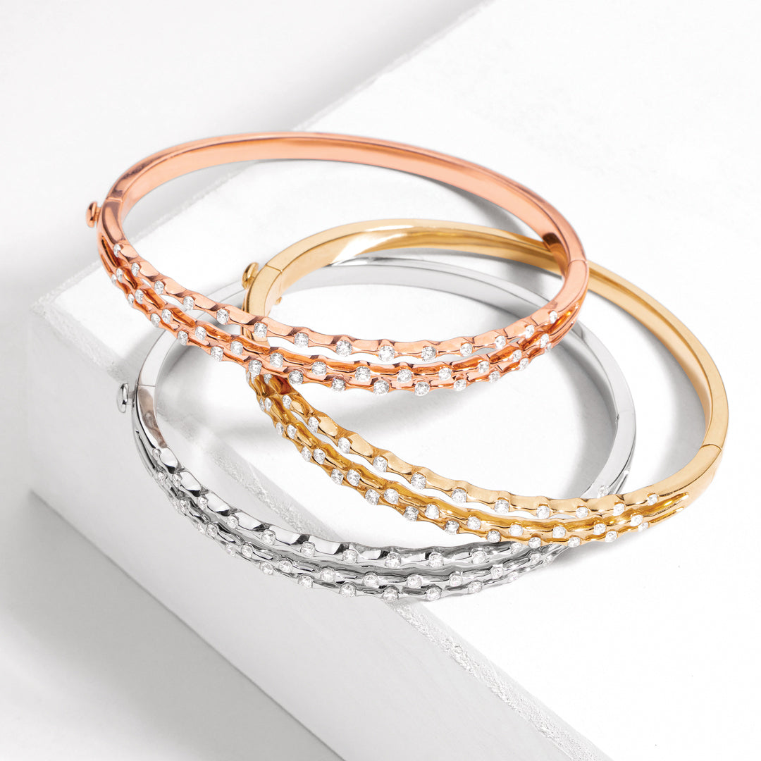 Wave Collection bangles in rose gold, yellow gold, and silver with diamond accents