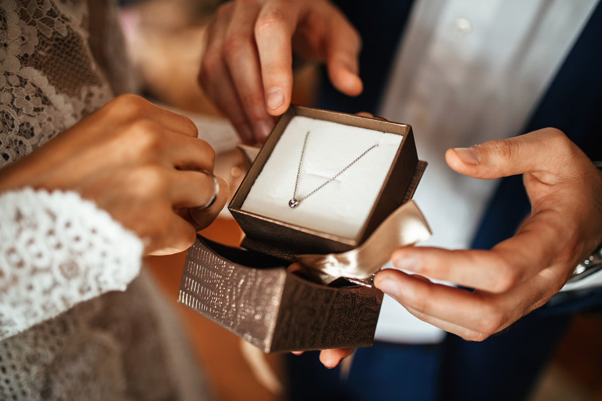 A Hamilton jewelry gift box being opened to reveal a diamond necklace