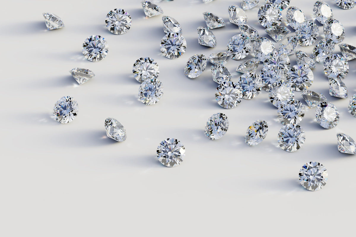 Loose round brilliant diamonds scattered on a white surface