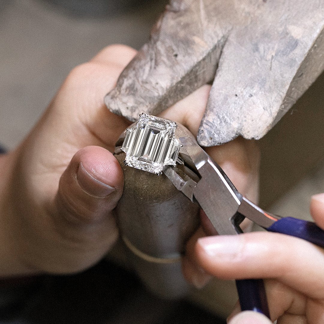 Jeweler setting an emerald-cut diamond in a ring